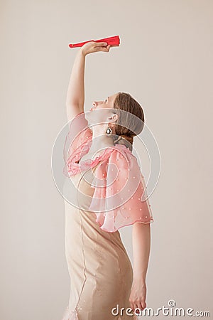 Portrait of a beautiful young woman in a beige and pink dress on a beige background. She is dancing flamenco. A hand with a red Stock Photo