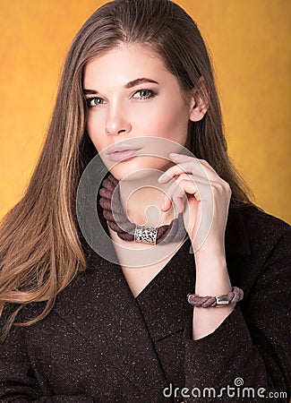 Portrait of beautiful young woman in a brown cloak with a necklace around his neck and a bracelet on her arm Stock Photo