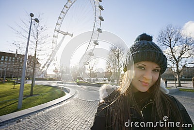Portrait of beautiful young woman in front of London Eye, London, UK Editorial Stock Photo