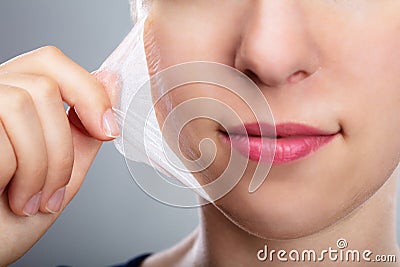 Woman Removing Peeling Mask From Her Face Stock Photo