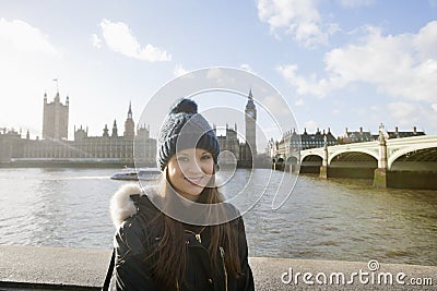 Portrait of beautiful young woman standing by river Thames, London, UK Editorial Stock Photo