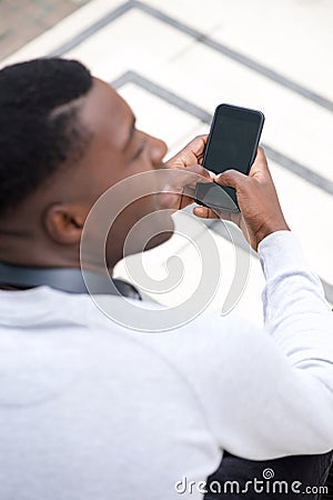 Behind of young black man holding mobile phone Stock Photo
