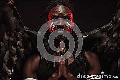 Serious black angel pray with closed eyes Stock Photo