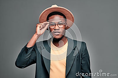 Portrait of black man with beard wearing in T-shirt and jacket, hat and glasses Stock Photo