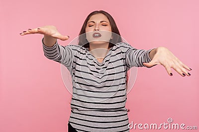 Portrait of blind disoriented woman in striped sweatshirt walking with closed eyes, trying to touch, find obstacles Stock Photo