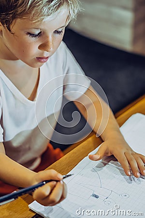 Portrait blond Preschool boy holding pen notebook look serious hard diligently diligently learn draw cute doodles Stock Photo