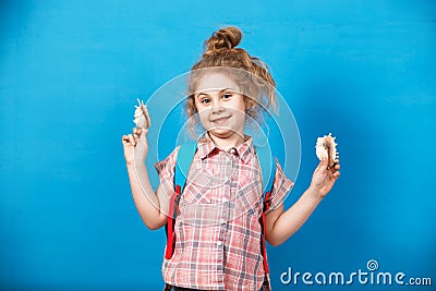 Portrait of blonde child girl listen a seashell at the blue wall. Summer vacation concept Stock Photo