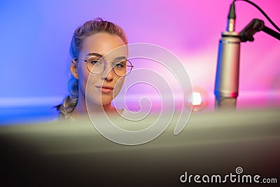 Portrait of Blonde Gamer Girl with Glasses Playing Online Video Game on Her Computer Stock Photo