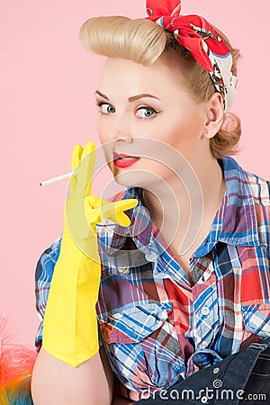 Blonde girl on pink background. Lady holds cigarette in hands with rubber gloves. Housewife smoking break. Stock Photo