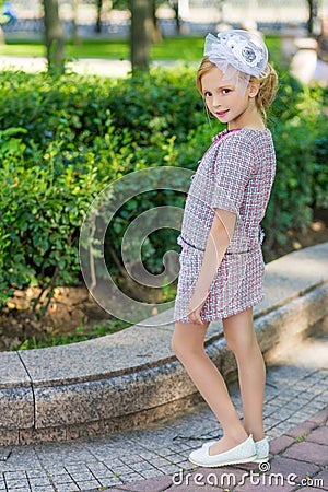 Portrait of a blonde in pink attire in a park outdoors. Stock Photo