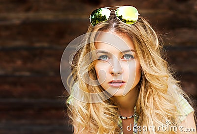 Portrait of Blonde Woman at the Wooden Wall Stock Photo