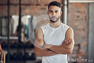 Portrait of bodybuilder with attitude in the gym. Young bodybuilder with arms crossed in the gym. Cool, fit man standing Stock Photo