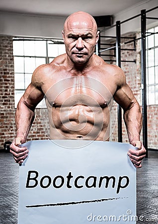 Portrait of bodybuilder holding placard with text bootcamp Stock Photo