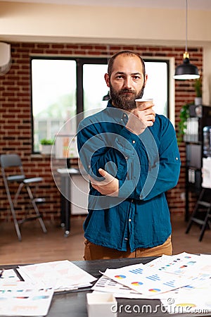 Portrait of bookkeeper man holding cup of coffee standing in startup company office Stock Photo