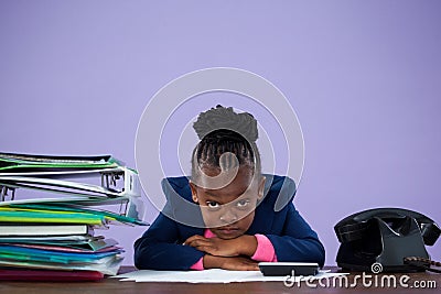 Portrait of bored businesswoman leaning by files and telephone Stock Photo