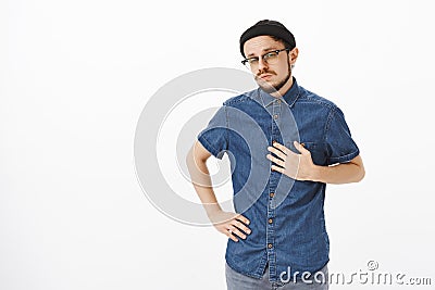 Portrait of bossy confident and handsome skillful male musician in black trendy beanie and shirt pointing at himself Stock Photo