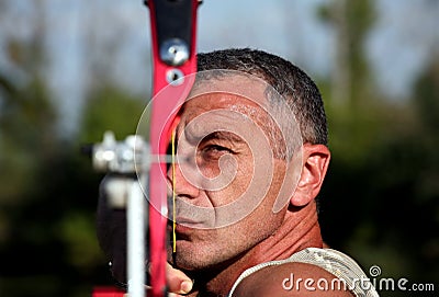 Portrait of bowman aiming with bow and arrow Stock Photo