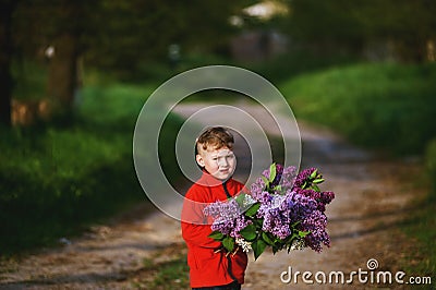 Portrait of a boy with a bouquet of lilacs . Stock Photo