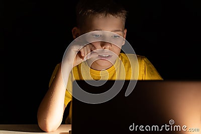 Portrait of a boy in front of a computer screen who communicates by video communication before bedtime Stock Photo