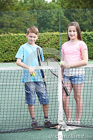 Portrait Of Boy And Girl Playing Tennis Together Stock Photo