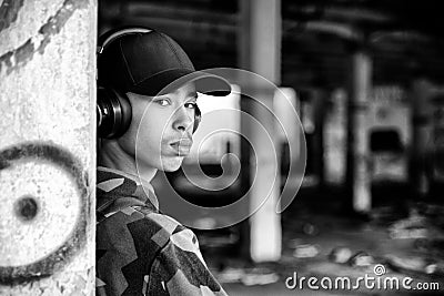 Portrait of boy with headphones and black cap on head inside of ruined building Stock Photo