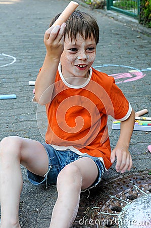 Scalawag chalking the street and his body Stock Photo