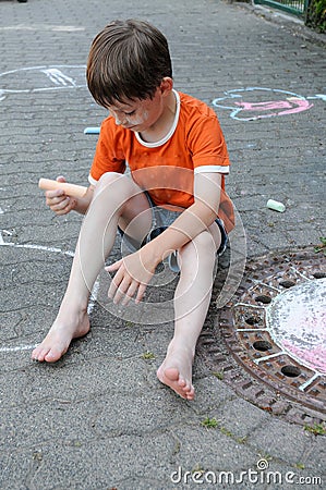 Scalawag chalking the street and his body Stock Photo