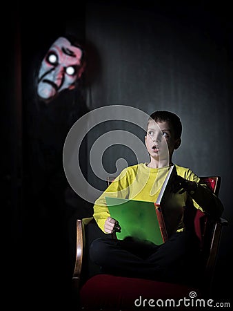 Portrait of a boy reading a book of spooky stories Stock Photo