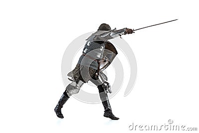 Portrait of brave medieval warrior, knight in special coat of mail attaching with sword isolated over white studio Stock Photo