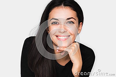 Portrait of brunette cute woman with beautiful and healthy toothy smile, with hand on chin. Stock Photo