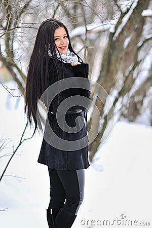 Portrait of brunette young woman in fur coat at winter background Stock Photo