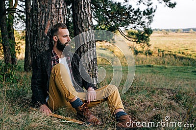 Portrait brutal bearded hipster man in the forest with ax Stock Photo