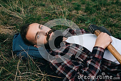 Portrait brutal bearded hipster man in the forest with ax Stock Photo