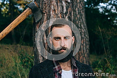 Portrait brutal bearded hipster man in the forest with ax Stock Photo