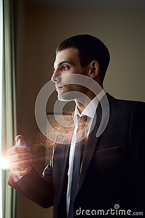 Portrait of a brutal man with Cologne in his hands, perfume fragrance for real men, perfume cosmetics. Perfume cologne bottle. Stock Photo