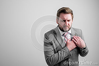 Portrait of business man wearing business clothes with his hand on his chest suffering from acute pain Stock Photo