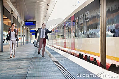 Portrait of business people running to catch the train in station Stock Photo