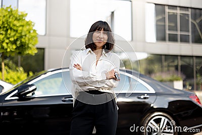 Portrait of business woman in front of a luxury car outdoors Stock Photo