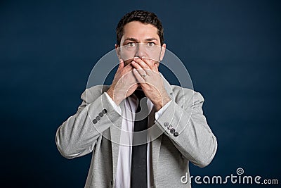 Portrait of business young male covering mouth like mute gesture Stock Photo