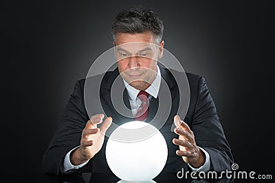 Portrait Of Businessman Predicting Future With Crystal Ball Stock Photo