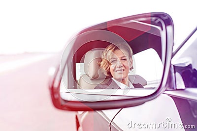 Portrait of businessman reflecting in side-view mirror of car Stock Photo