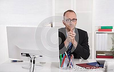 Portrait: Businessman sitting in his office with suit and tie. Stock Photo