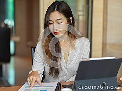 Portrait of businesswoman looking on financial paper with tablet Stock Photo