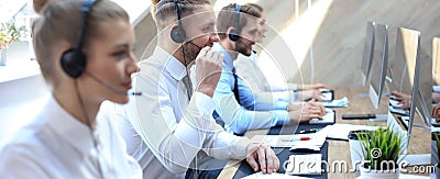 Portrait of call center worker accompanied by his team. Smiling customer support operator at work Stock Photo