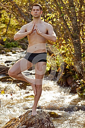 Portrait of calm caucasian male standing on rock meditating Stock Photo