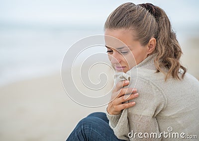 Portrait of calm woman sitting on cold beach Stock Photo