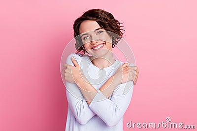 Portrait of candid girl hug herself enjoy self love wear pullover isolated over pastel color background Stock Photo