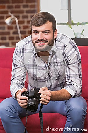 Portrait of casual photo editor holding camera Stock Photo