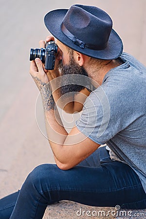 Street photographer sits on a step. Stock Photo