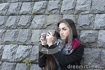 Portrait of casual woman taking pictures with retro camera. Stock Photo